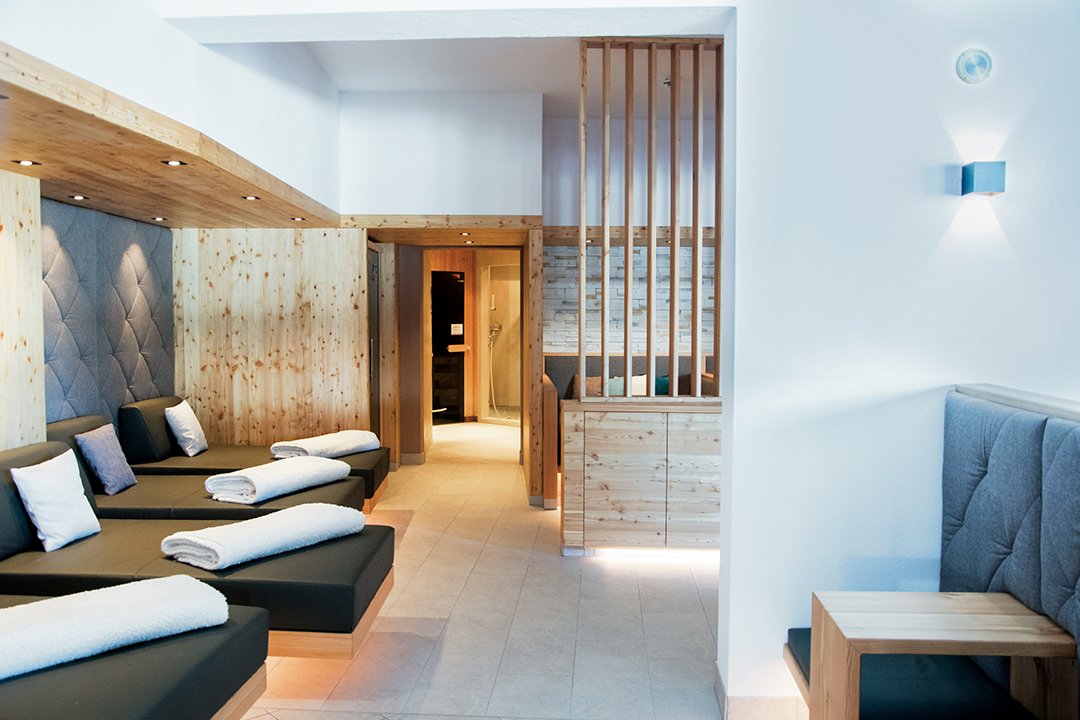 Bright spa lounge with loungers, wood paneling and cozy seating