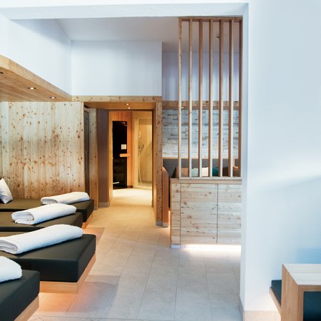 Bright spa lounge with loungers, wood paneling and cozy seating