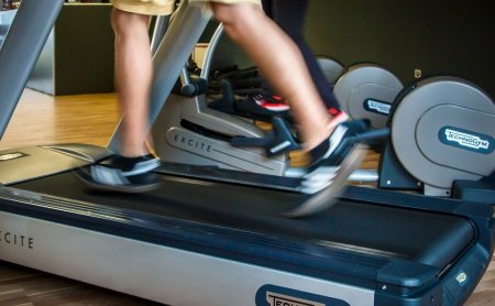 Legs in motion on a treadmill in a Technogym fitness room