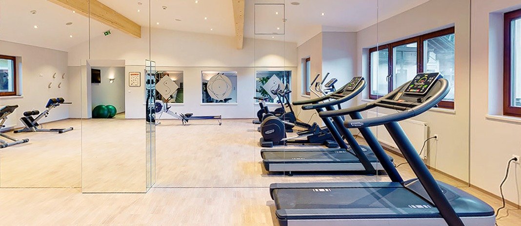Fitness room with mirror wall and Technogym equipment